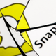 The Snapchat logo is shown reflected in a broken mirror.